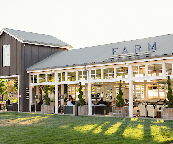 The image shows a barn-style building with a sign reading 